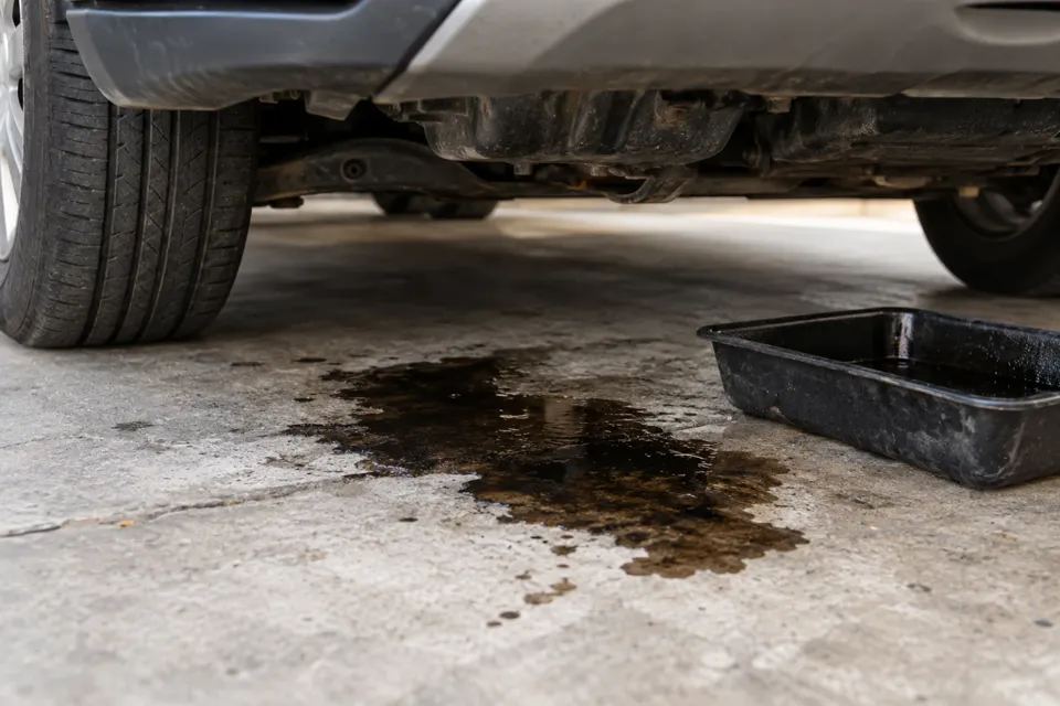 Mancha de aceite debajo de un auto estacionado